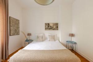 科爾馬的住宿－MAMRAY，卧室配有一张带两张桌子的大型白色床