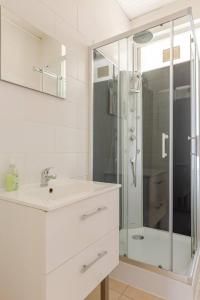 a white bathroom with a sink and a shower at MAMRAY in Colmar