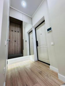een lege kamer met 2 deuren en houten vloeren bij 2-х комнатные апартаменты в ЖК GreenLine.Asyl Mura in Taldykolʼ
