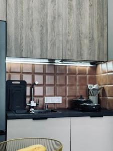 een keuken met houten kasten en een aanrecht bij 2-х комнатные апартаменты в ЖК GreenLine.Asyl Mura in Taldykolʼ