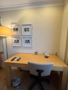 a desk with a white chair and a desk with a lamp at Flat Hotel Aeroporto Congonhas UH1109 in São Paulo +8 photos