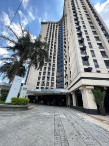 a large building with a palm tree in front of it at Flat Hotel Aeroporto Congonhas UH1109 in São Paulo