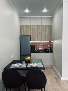 een kleine keuken met een tafel en 2 stoelen bij 2-х комнатные апартаменты в ЖК GreenLine.Asyl Mura in Taldykolʼ