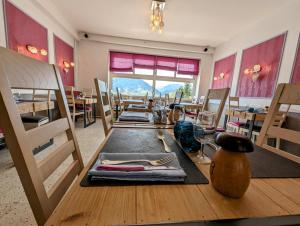 拉克河畔尚邦的住宿－Logis Hôtel Le Beau Site，用餐室配有木桌、椅子和桌子
