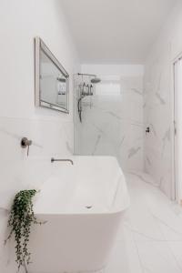 霍巴特Stay steps from Salamanca in historical cottage的带浴缸和水槽的白色浴室