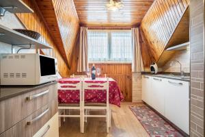 a kitchen with a table with a red table cloth at House Cuel Milena Folgaria - Green in Folgaria