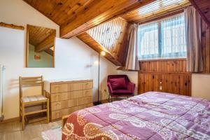 a bedroom with a bed and a chair at House Cuel Milena Folgaria - Green in Folgaria