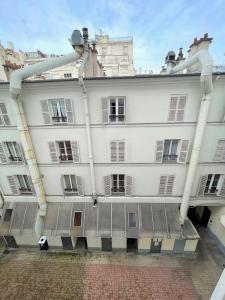 巴黎的住宿－Studio Jean Mermoz CityCosy，一座白色的大建筑,上面有管道