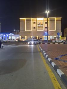 een auto geparkeerd voor een tankstation 's nachts bij الساعه 60 الفندقيه in Dammam