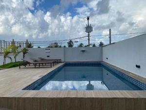 a swimming pool with a picnic table next to a building at Bela Hospedagem - #Wind Palace 606 Intermares in Cabedelo