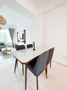a dining table and chairs in a living room at Juan Dolio Apartamento 204D 2Br Pool View in Juan Pedro