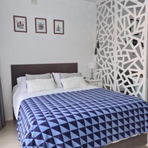 sypialnia z łóżkiem z niebiesko-białym kocem w obiekcie Departamentos Condominio Wyndham Nordelta - Desayuno y Spa Opcional ! w mieście Tigre