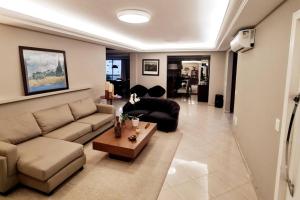 uma sala de estar com um sofá e uma mesa em Campinas Penthouse - Cobertura Luxo com Piscina Privativa em São José