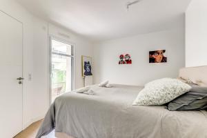 een slaapkamer met een bed met twee foto's aan de muur bij Chic appartement en plein coeur de Levallois-Perret in Levallois-Perret