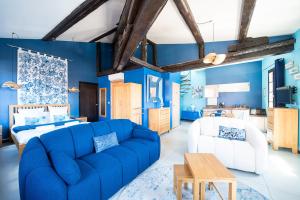 sala de estar con paredes azules y sofá azul en Suites Coronell d'En Vila en Perpiñán