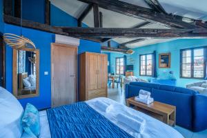 Habitación azul con cama y sofá en Suites Coronell d'En Vila en Perpiñán