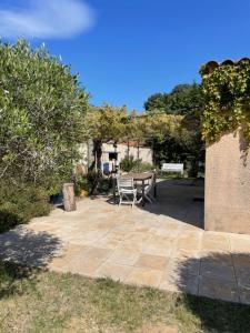 un patio con mesa, sillas y árboles en Villa Provencale au bord de mer, en Martigues
