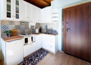 a kitchen with white cabinets and a wooden door at Kaimaktsalan maisonette in Palaios Agios Athanasios