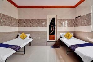 two beds in a room with a window at SPOT ON Hotel Maha Lakshmi in Ongole