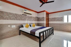 OngoleにあるSPOT ON Hotel Maha Lakshmiのベッドルーム1室(ベッド1台、シーリングファン付)
