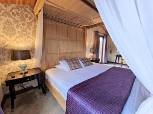a bedroom with a bed and a table with a lamp at Lomond 6 with Private Hot Tub - Fife - Loch Leven - Lomond Hills in Kelty