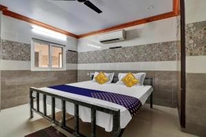ein Schlafzimmer mit einem Bett in einem Zimmer in der Unterkunft SPOT ON Hotel Maha Lakshmi in Ongole
