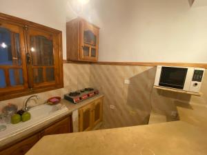 a kitchen with a sink and a microwave oven at Dar Alaa in Tozeur