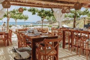 ein Restaurant mit Tischen und Stühlen und Meerblick in der Unterkunft Cap St Georges Villas in Peyia