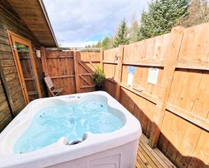 a hot tub on a deck with a wooden fence at Lomond 6 with Private Hot Tub - Fife - Loch Leven - Lomond Hills in Kelty