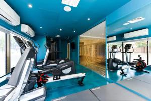 einen Fitnessraum mit blauen Wänden und Laufbändern in der Unterkunft Vibrant Byrom Point Retreat with Gym, Study Room and Social Lounge for Students Only in Liverpool