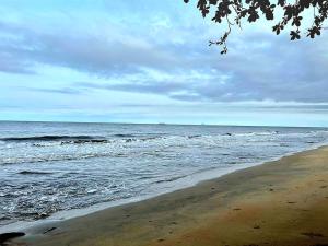 a beach with the ocean on a cloudy day at Akiba Guests Houses in Kribi