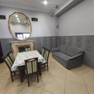 a dining room with a table and a couch and a mirror at Pensjonat Sielec in Sosnowiec