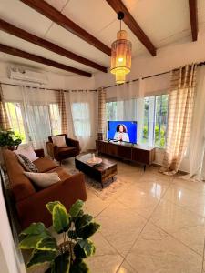 a living room with a couch and a tv at Akiba Guests Houses in Kribi