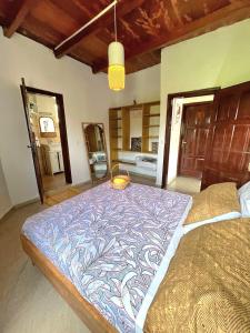 a bedroom with a large bed with a blue blanket at Akiba Guests Houses in Kribi