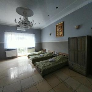 1 dormitorio con 2 camas y lámpara de araña en Pensjonat Sielec en Sosnowiec
