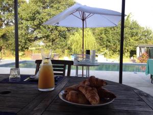 a table with a plate of bread and a glass of orange juice at Le Mazet Chambre d'Hôtes in Mauguio