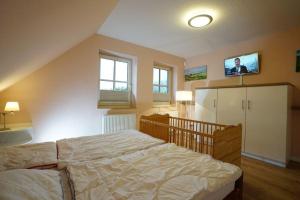 a bedroom with a bed and a tv on the wall at Ferienwohnung Seewind am Schweriner See in Flessenow +14 photos