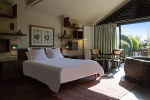 a bedroom with a large white bed and a tub at La Mare aux Oiseaux, The Originals Collection in Saint-Joachim +82 photos