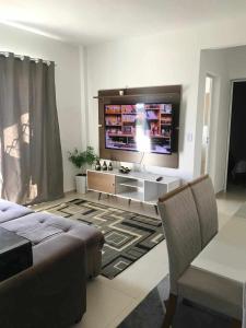 a living room with a flat screen tv and a couch at Apartamento belvedere do lago in Serra Negra
