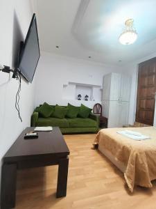 ein Wohnzimmer mit einem grünen Sofa und einem Tisch in der Unterkunft Guest House Lili in Batumi