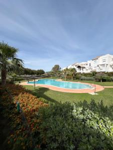 - une piscine dans un parc fleuri dans l'établissement LA CASA DE LOS PATOS Jardines del lago, à Costa de Sanlúcar
