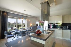a kitchen and dining room with tables and chairs at Luxury Villa Helanes in Corfu Town