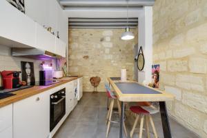 a kitchen with a table and some chairs in it at Perle rare au coeur de Bordeaux in Bordeaux