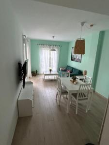 un salon avec une table et des chaises blanches dans l'établissement LA CASA DE LOS PATOS Jardines del lago, à Costa de Sanlúcar