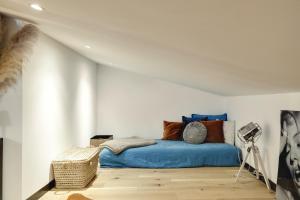 a bedroom with a blue bed in a white wall at Perle rare au coeur de Bordeaux in Bordeaux