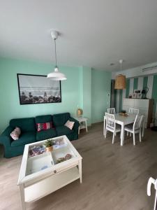 un salon avec un canapé vert et une table dans l'établissement LA CASA DE LOS PATOS Jardines del lago, à Costa de Sanlúcar