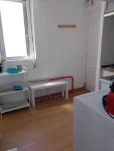 Habitación blanca con ventana y banco en Apartamento Chamberí, en Madrid