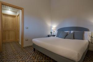 1 dormitorio con 1 cama blanca grande con almohadas azules en Masseria Agriturismo Torre Di Albidona, en Trebisacce
