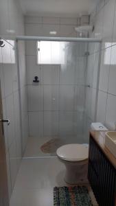 a bathroom with a shower with a toilet and a sink at Apartamento belvedere do lago in Serra Negra
