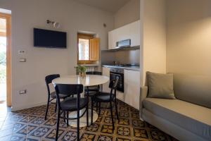 - un salon avec une table, des chaises et un canapé dans l'établissement Masseria Agriturismo Torre Di Albidona, à Trebisacce